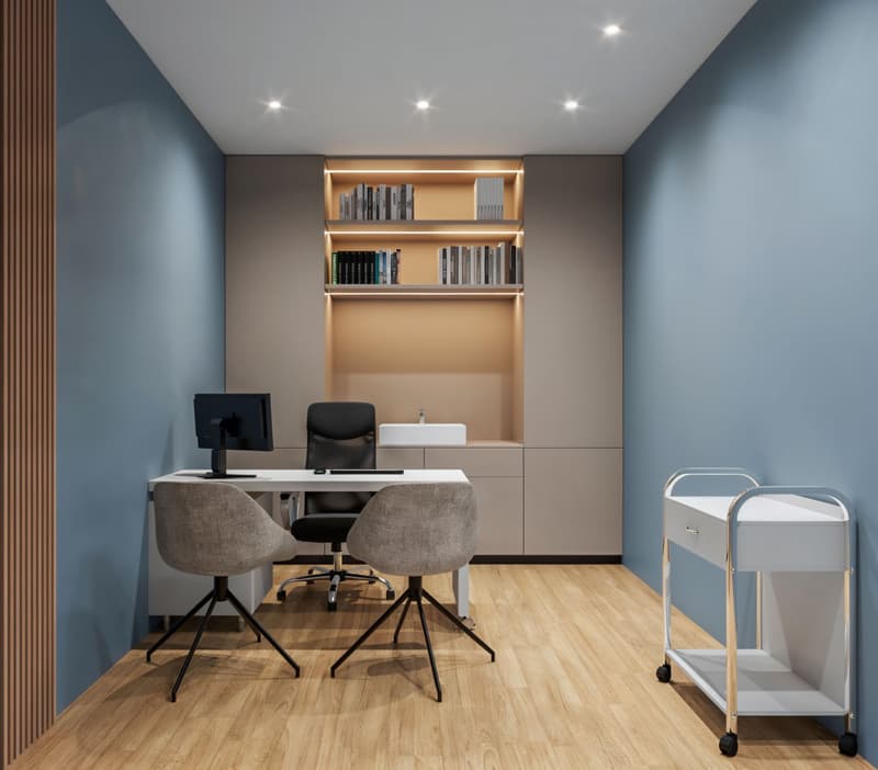 modern office room with blue walls, wooden floor, white desk, two chairs, monitor, shelves with books, sink, and a rolling cart