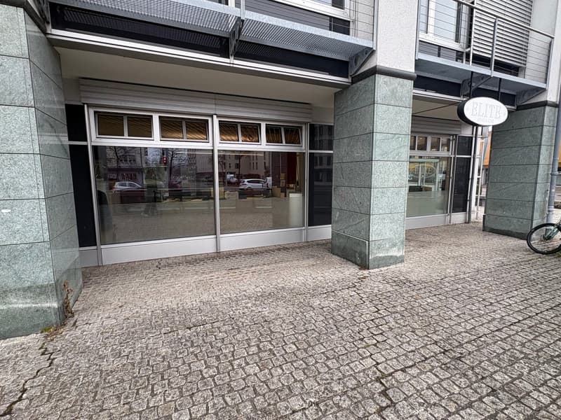 Modern office building, glass storefront, steel columns, brick paved entrance, bike