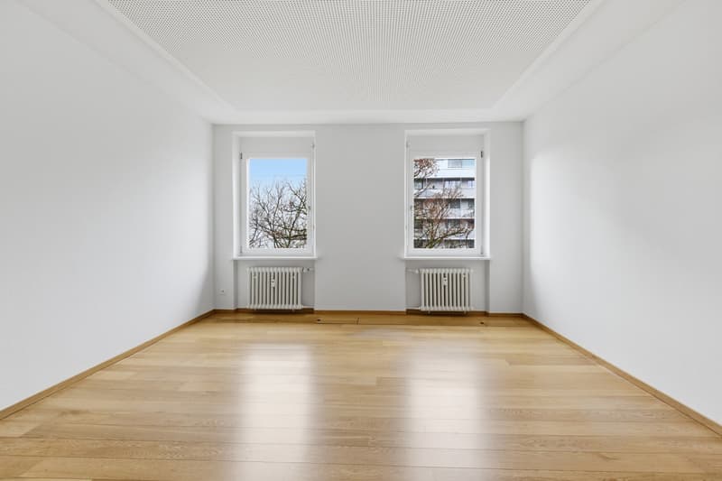 empty room, white walls, wooden floor, two windows, radiators