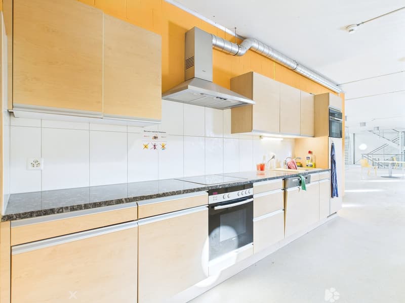 Modern kitchen with white cabinets, granite countertops, built-in oven and dishwasher, and yellow accent walls.