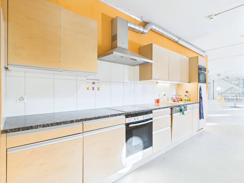 Modern kitchen with white cabinets, granite countertops, built-in oven and stove, dishwasher, and washing machine