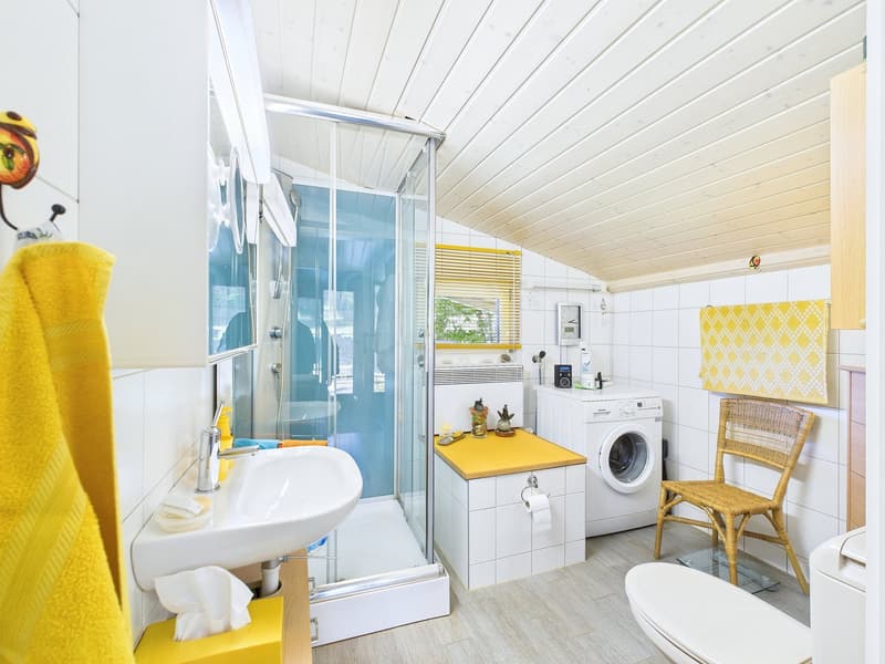 shower stall, washing machine, sink, toilet, wicker chair, towel