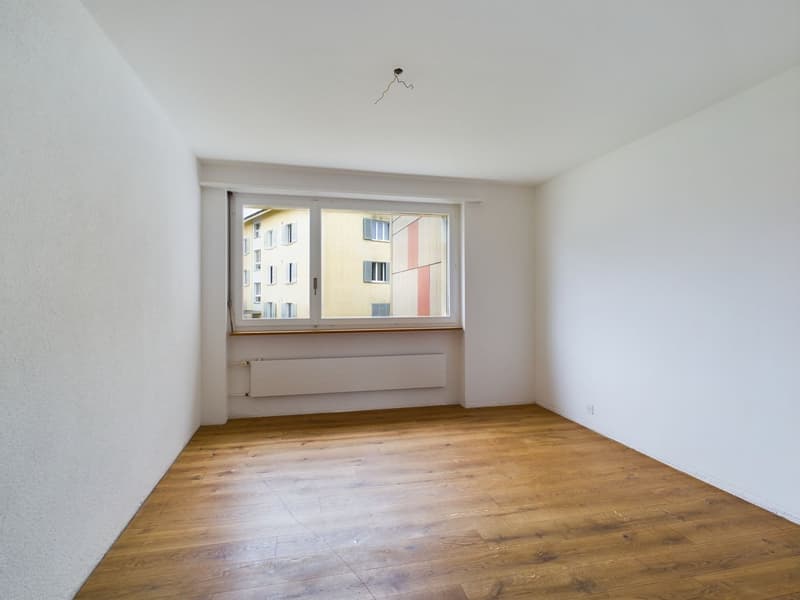 empty room, white walls, wooden floor, large window, radiator