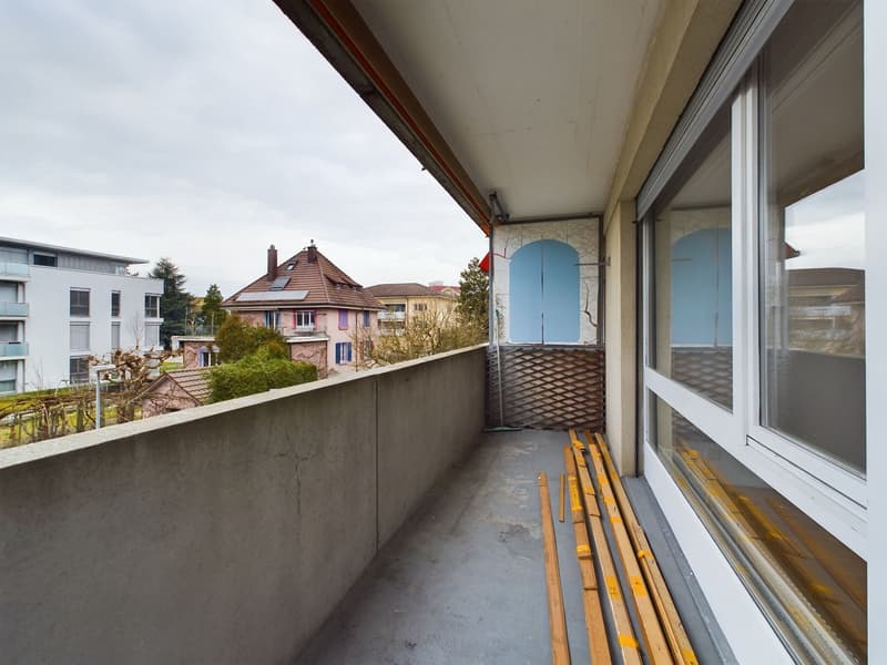 empty balcony with concrete wall, wooden planks, glass windows, metal railing