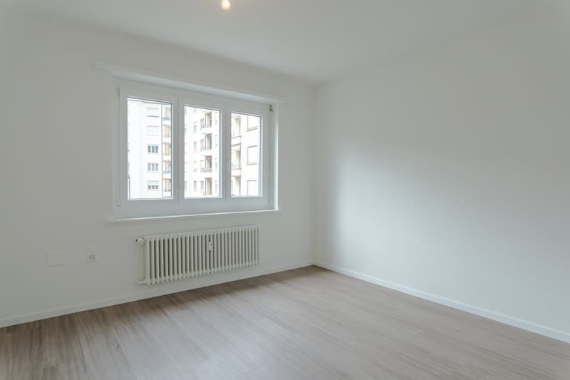 empty room, white walls, wooden floor, white radiator, window