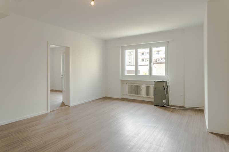 empty room, wooden floor, white walls, window, radiator, air conditioner