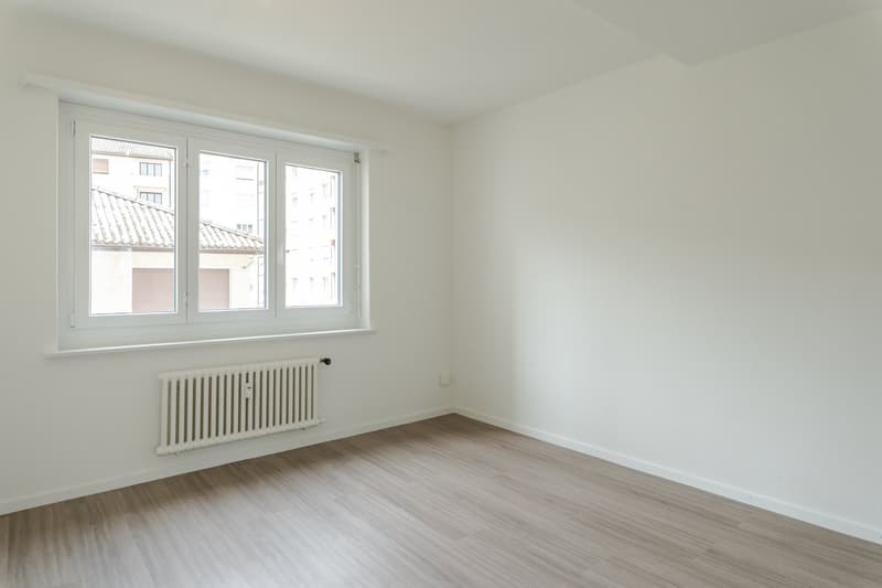 empty room, white walls, wooden floor, white radiator, window