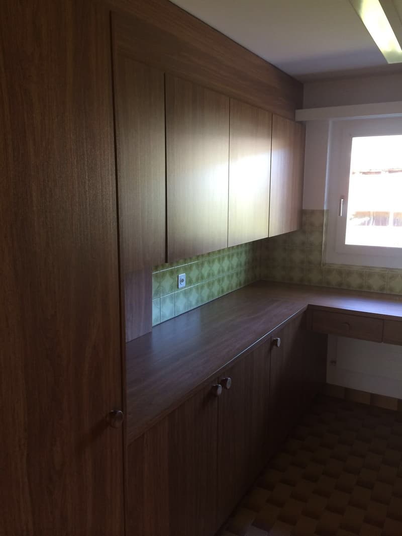 Wooden cabinets, tiled wall, window, power outlet