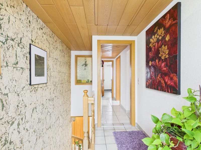 Decorative paint on walls, a picture frame, a wooden railing, tiled floor, and an entrance