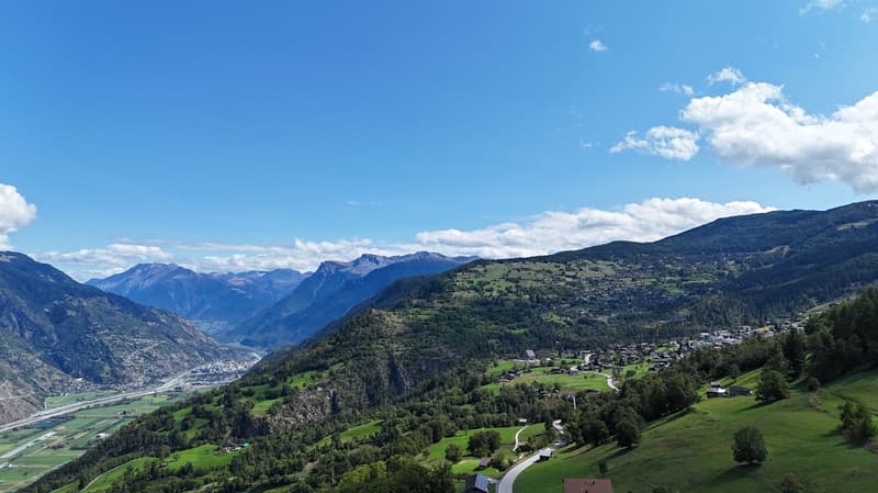 Mountains in the background, roads in the valley, green grass