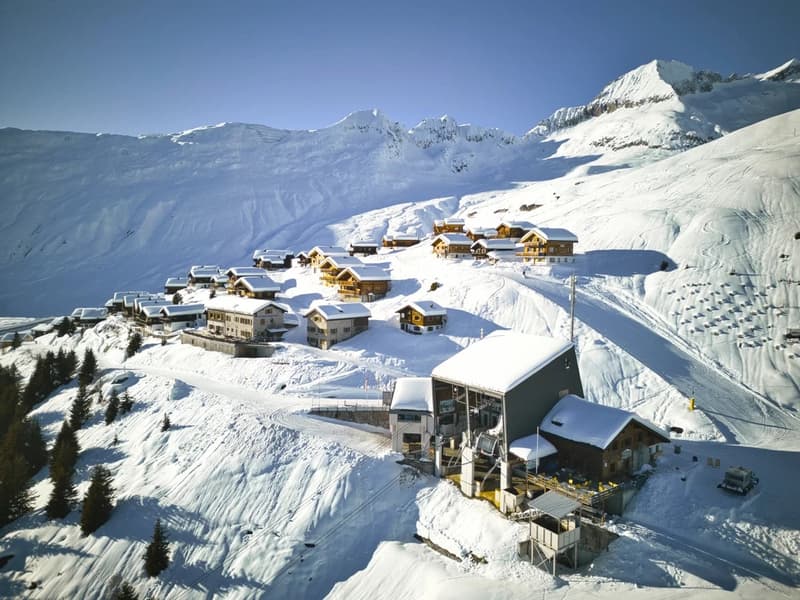 wooden chalets nestled on snowy mountains