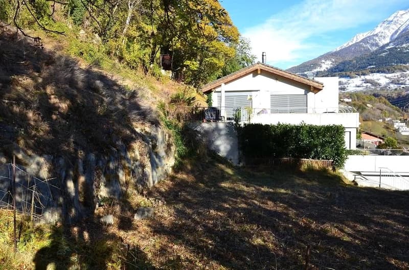 House on hillside with balcony, small yard, mountain view