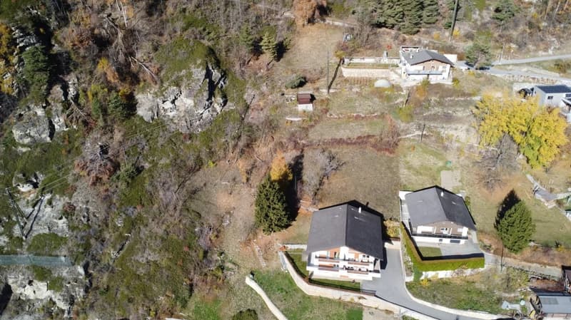 Two detached houses on a hill with a sloping terrain