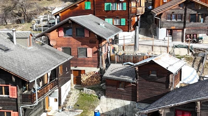 Cluster of wooden houses with multiple floors and balconies.