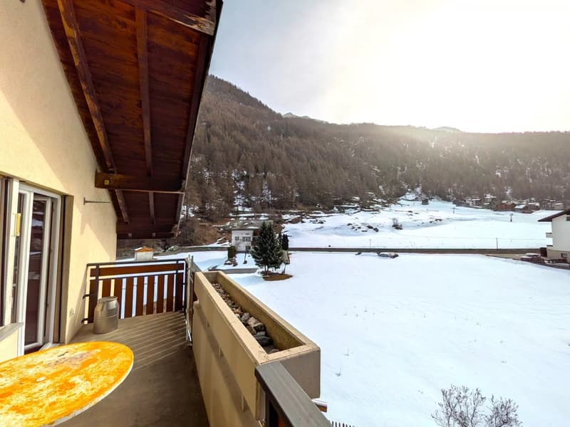 balcony with wooden railing, table, view of snowy mountain