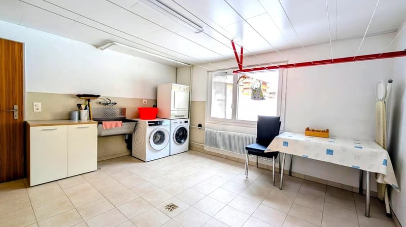 white tiled floor, white cabinets, washing machine, dryer, sink, table, chair, radiator, window