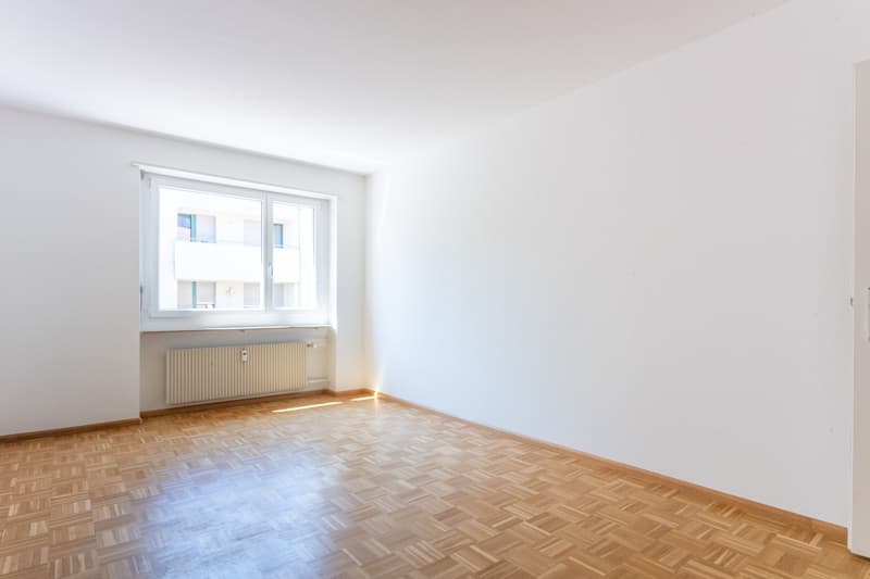 empty room, white walls, wooden parquet floor, large window, radiator