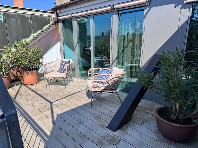 Wooden deck, glass sliding doors, patio furniture, potted plants