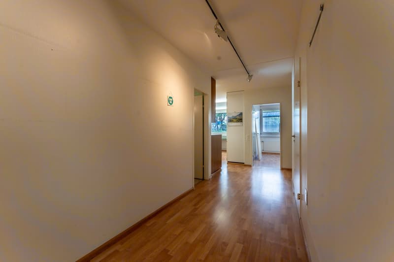 empty hallway, wooden floor, doors on both sides, lights