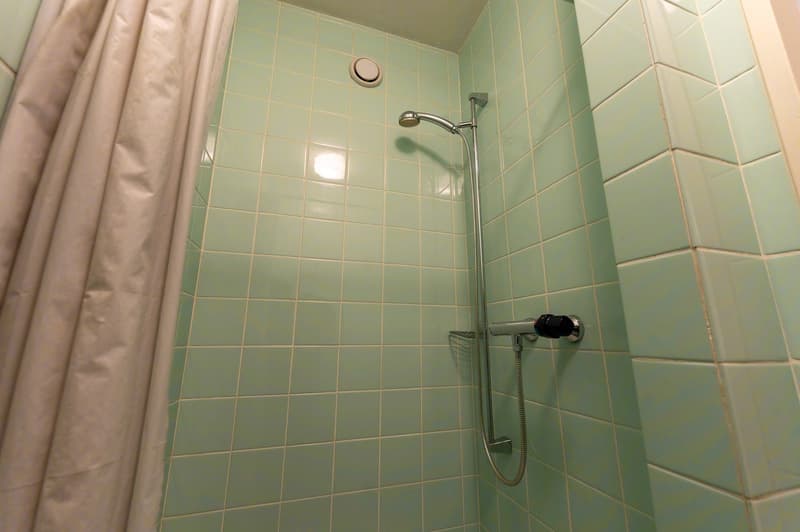 light green tiled walls, light green tiled floor, shower head, faucet, vent
