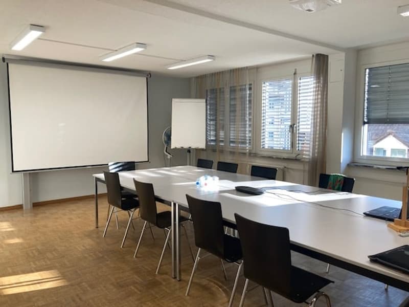 conference room, projector, whiteboard, long tables, rows of chairs