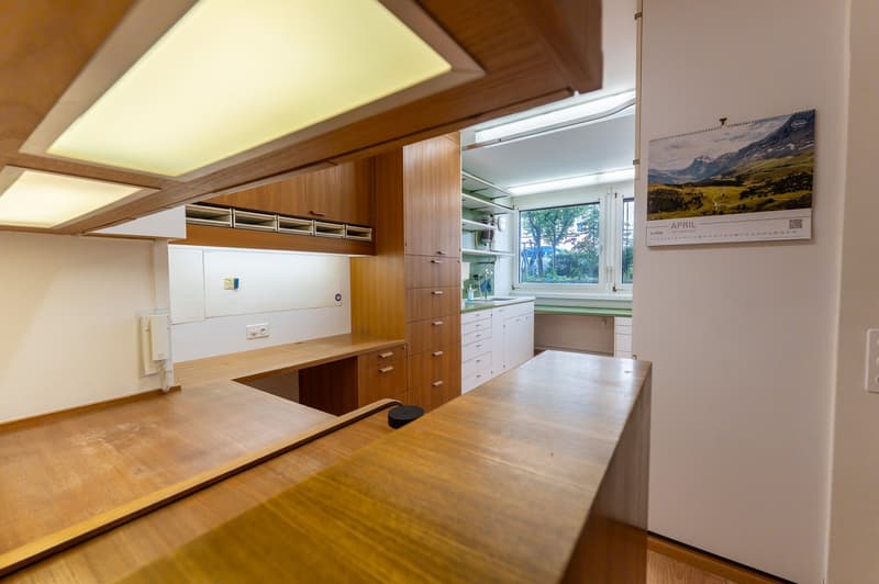wooden cabinets, wooden countertops, white walls, window, calendar on wall
