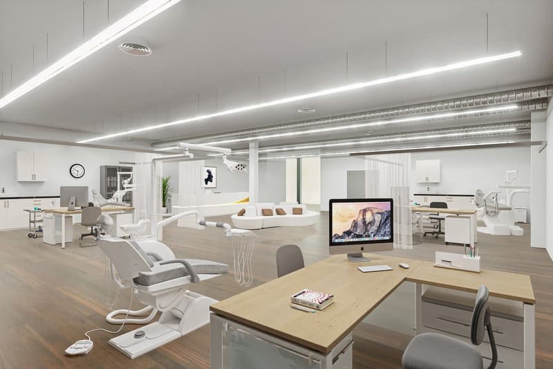 Interior space resembling a modern dental clinic with hardwood floors, various dental chairs, computers, cabinets, and shelves. A distinct feature is a monitor displayed prominently with a mountain landscape.