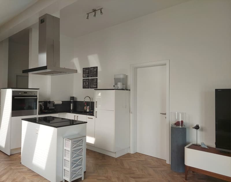 modern kitchen, white cabinets, black countertops, stainless steel appliances, wooden floor