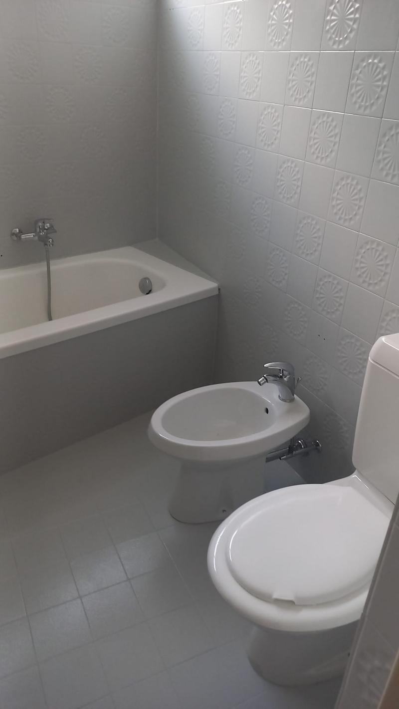 Bathtub, toilet, bidet, white tiles, silver faucets