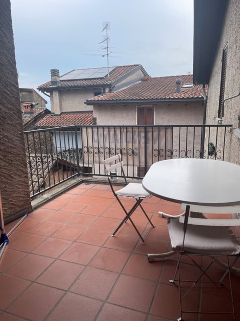 outdoor table and chairs on tiled floor, black railings