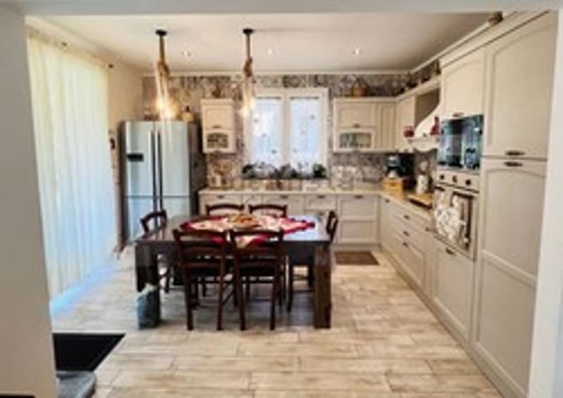 white cabinets, tile floor, refrigerator, dishwasher, wooden table, dining chairs, windows, view of outdoors