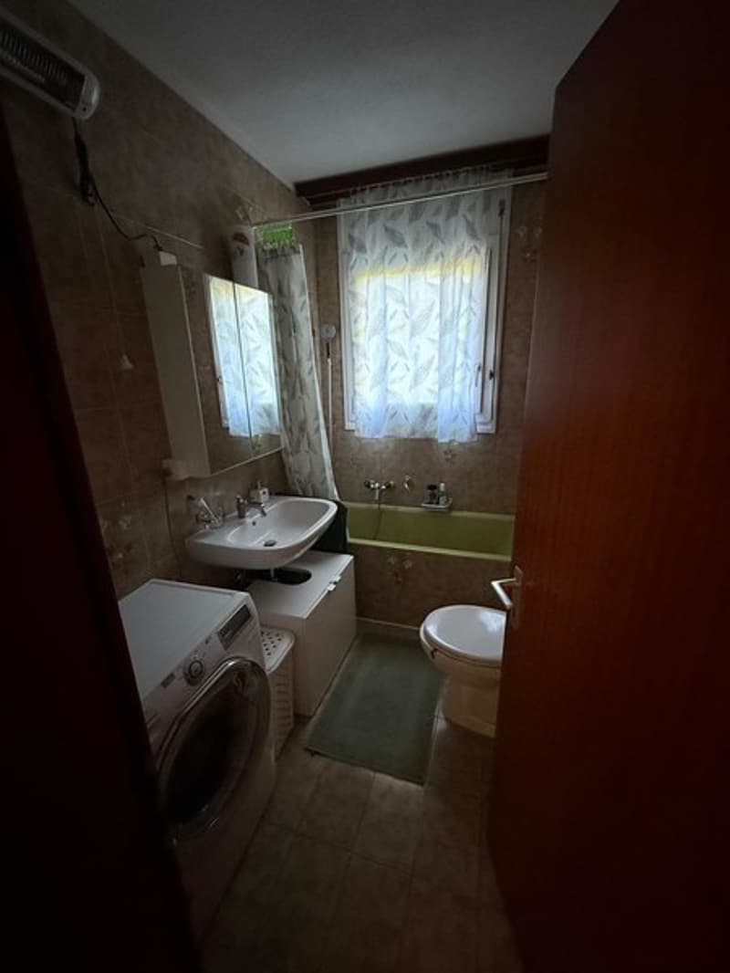 Bathtub, toilet, sink, washing machine, rug, air conditioner, window, curtain