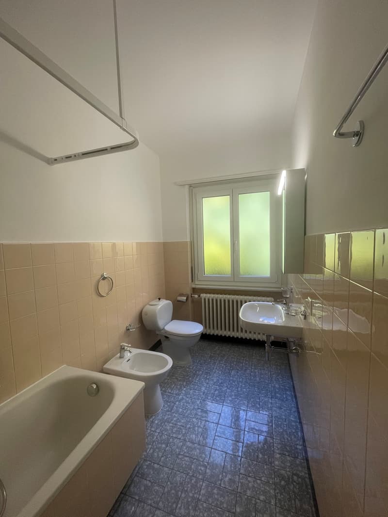 Bathroom: white bathtub, bidet, toilet, radiator, single sink, small window