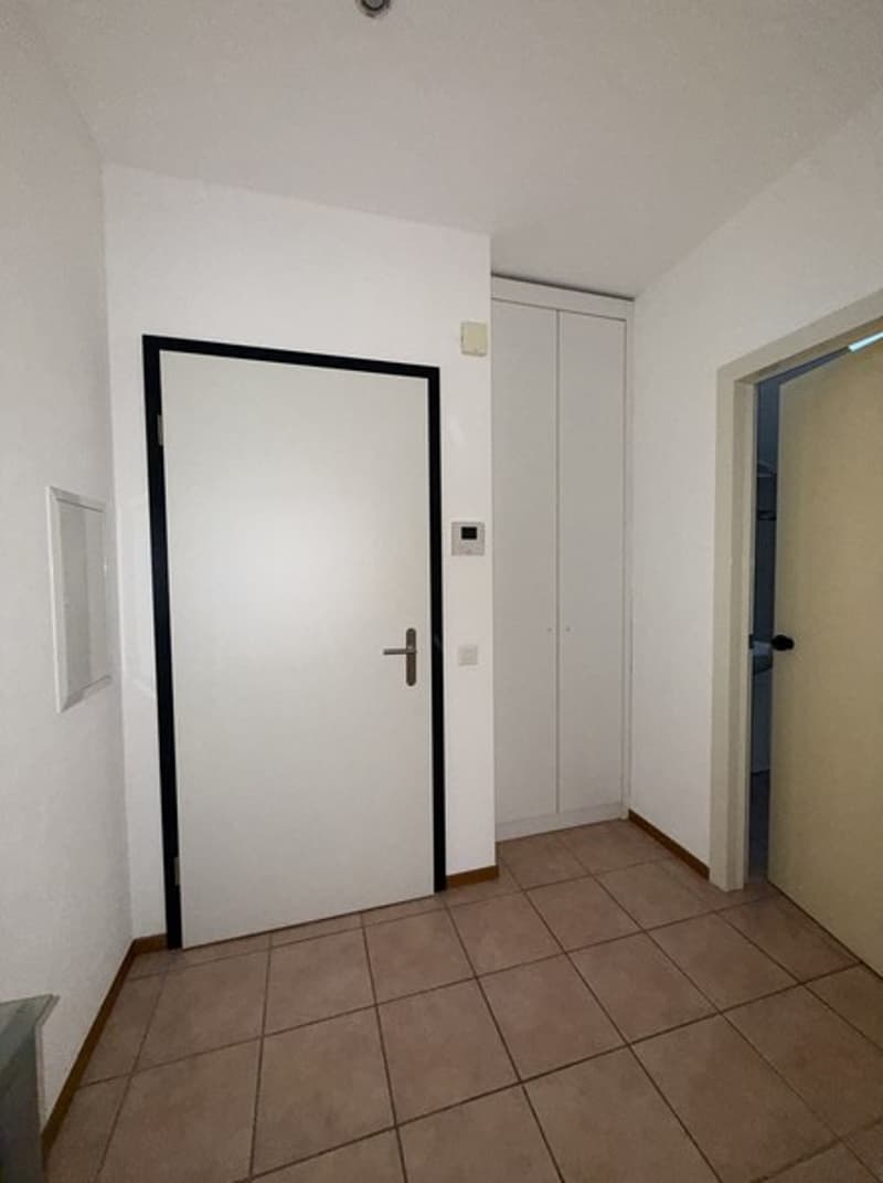empty room, tile floor, white walls, white door, cabinet in the corner