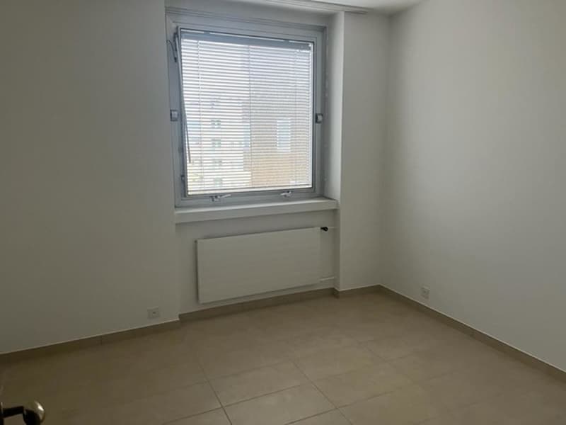 empty room, white walls, tiled floor, window with blinds, radiator