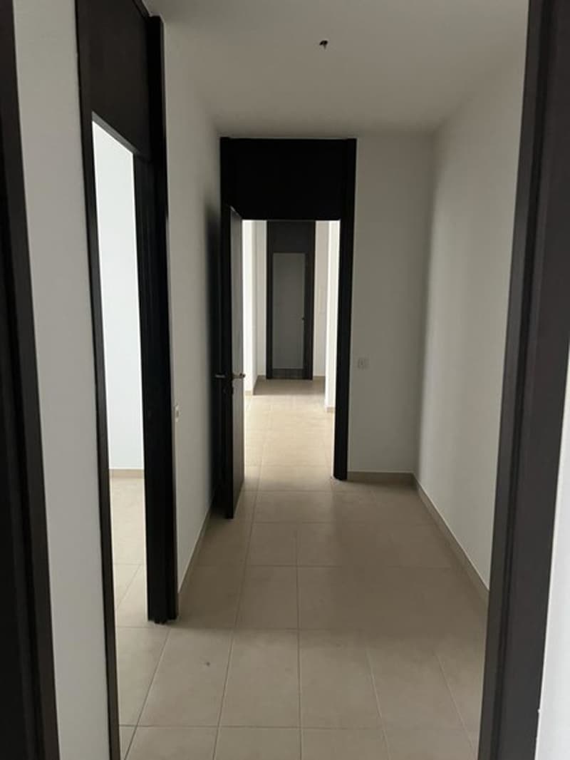 Three doors in a row, tiled floor, illuminated by a ceiling light