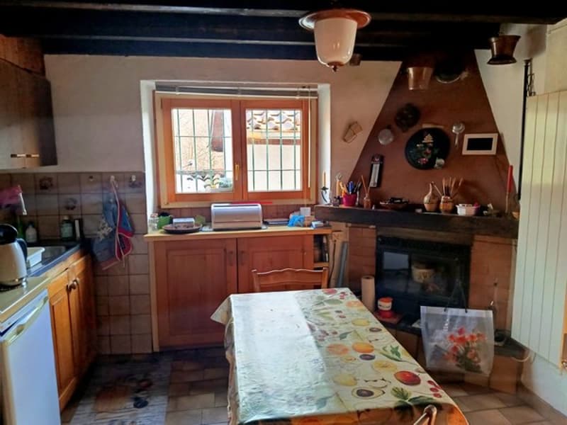kitchen with wooden counter, window, fireplace, table, and chairs