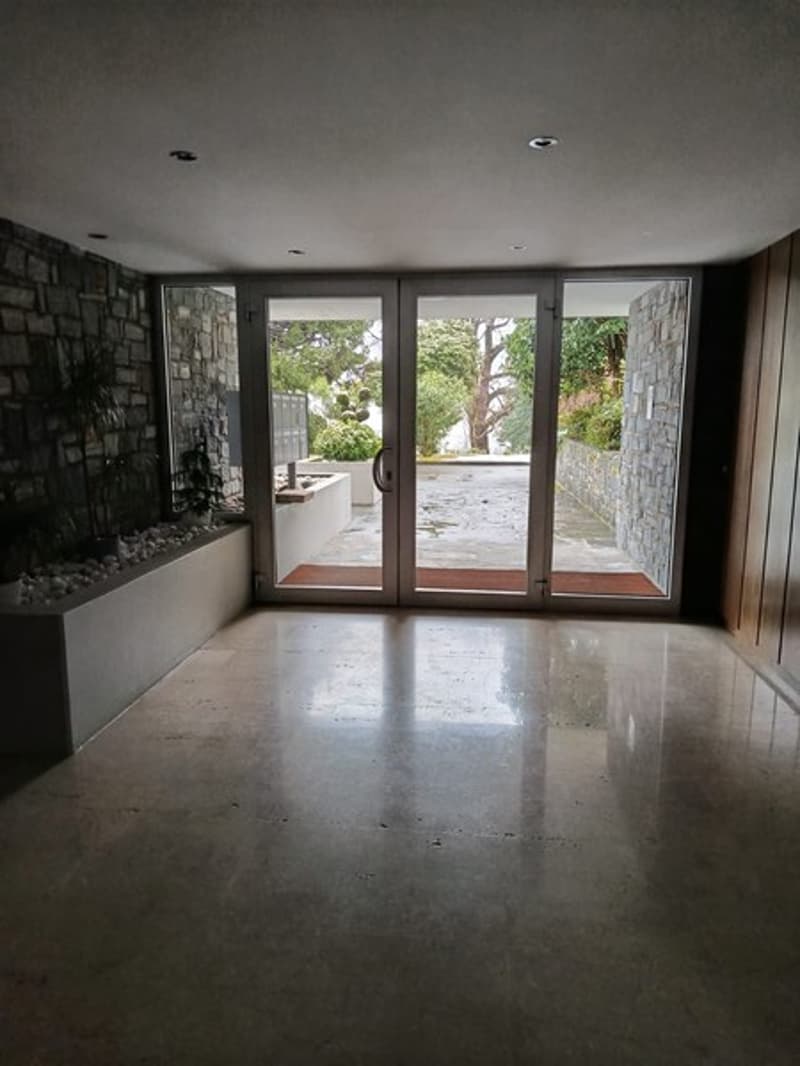 open room, glass sliding doors, concrete floor, stone wall