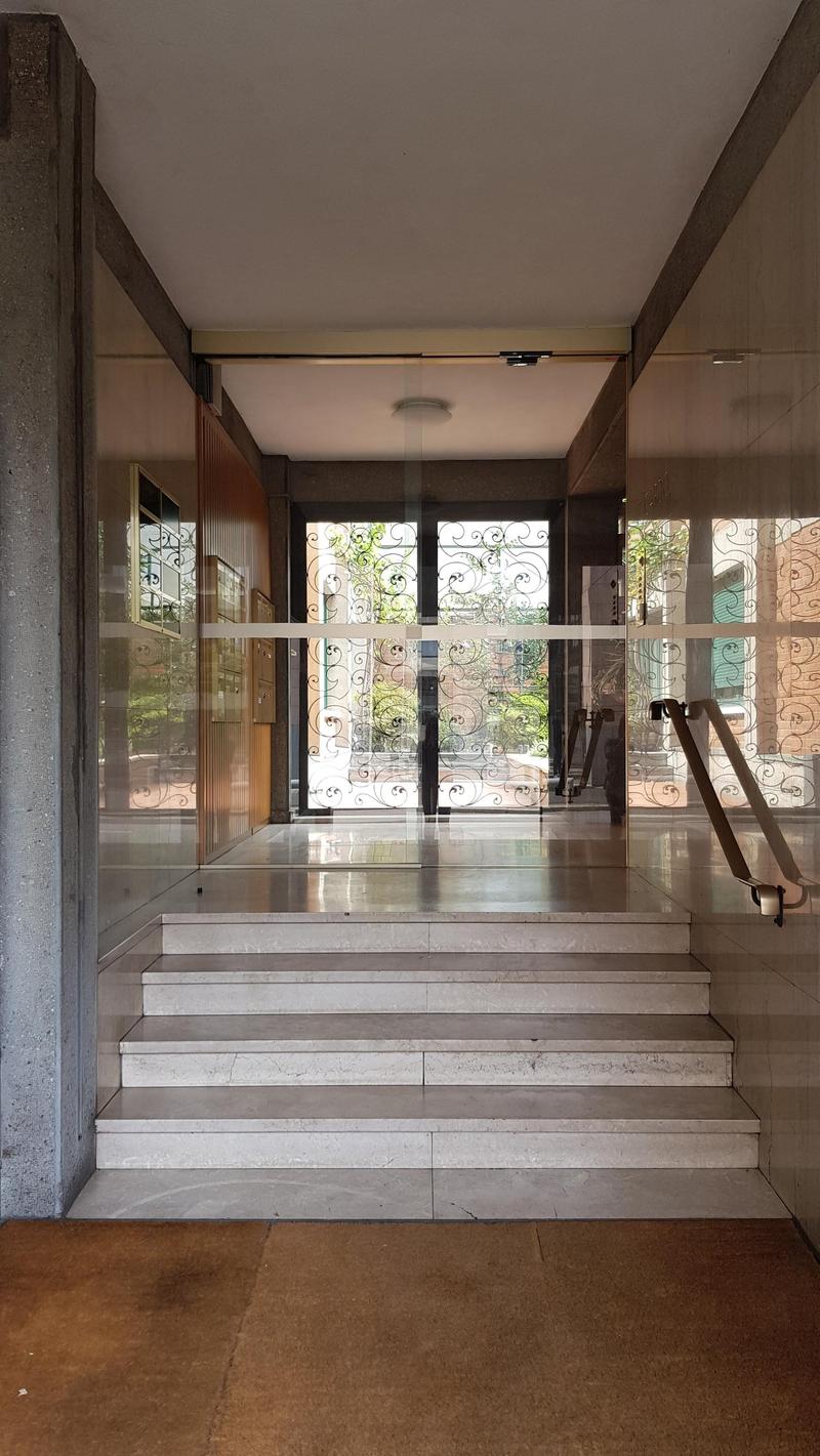 House entrance, marble steps, glass railings, wooden panelling, automatic door