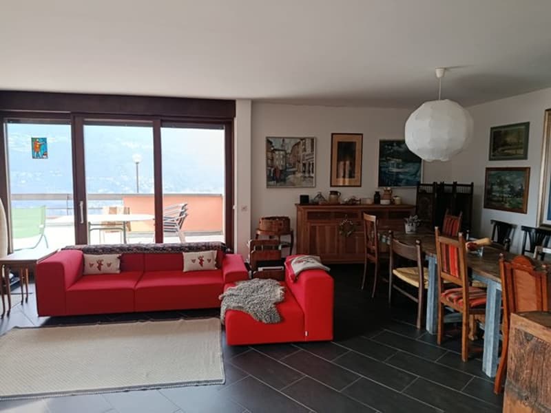 large windows, balcony, red couches, dining table, wooden chairs, wooden cabinet, paintings