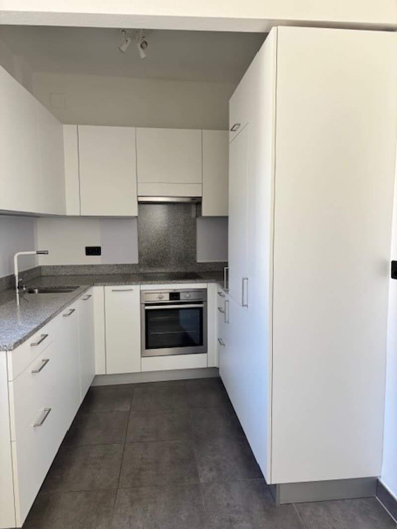 modern kitchen with white cabinets, granite countertops, stainless steel appliances, and a sink with a faucet