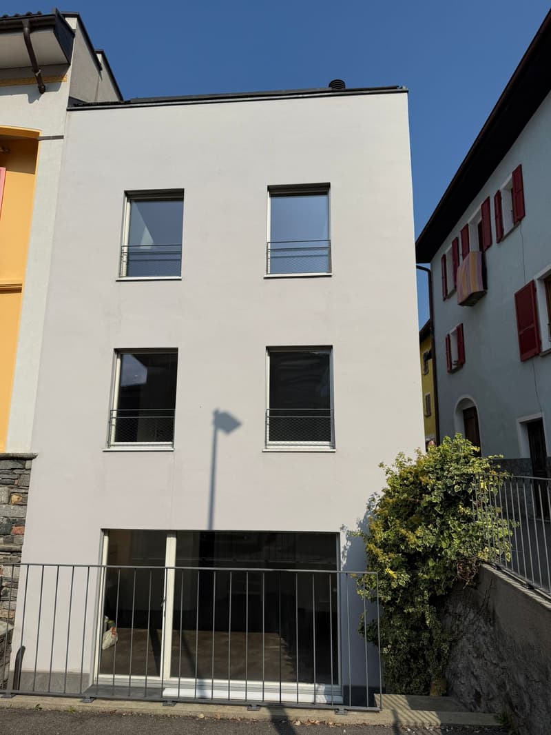 3 story house, white exterior, metal railings, 3 balconies, 1 garage, stone walkway