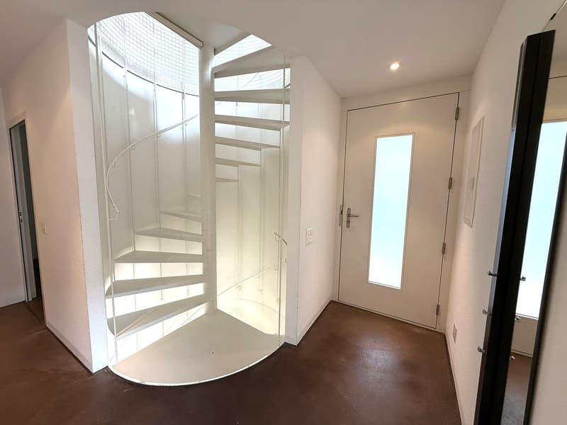 Glass spiral staircase, white walls, dark brown flooring, glass door with a transparent window