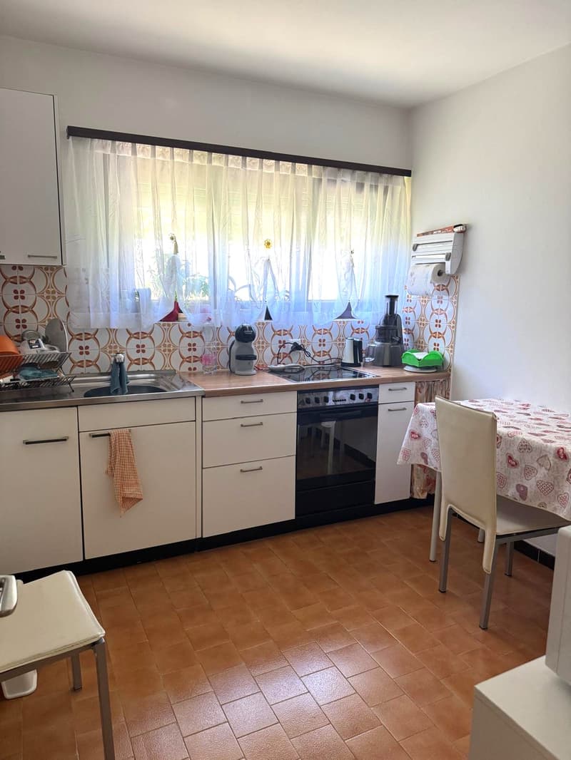 white kitchen, tiled floor, stainless steel appliances, dishwasher, washing machine, cabinets, drawers, window with curtains, stove, oven, countertop, dining table