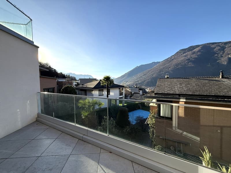 Glass railing balcony, mountain view, tiled floor, reflective glass wall