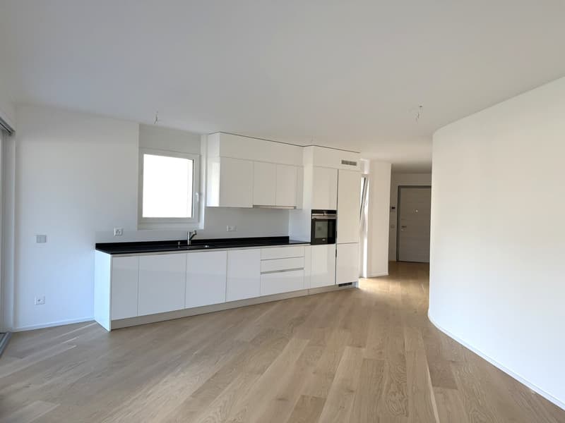 white cabinets, black counter, wooden floor, window, sink, oven