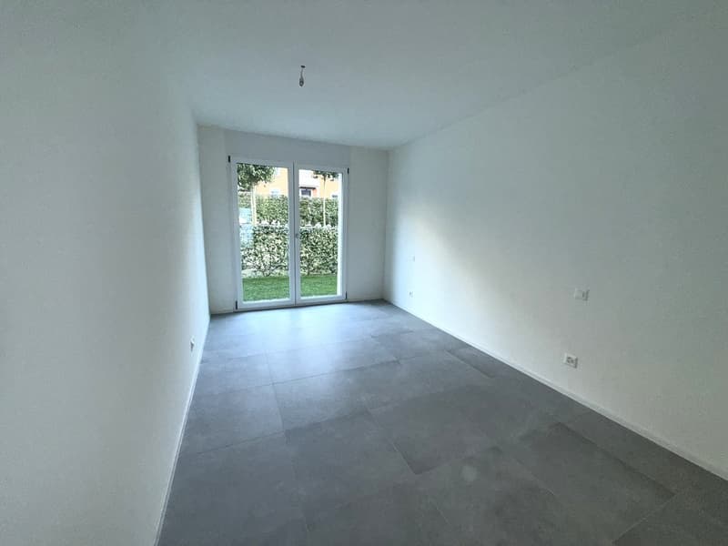 empty room, white walls, tile floor, sliding glass doors leading to balcony
