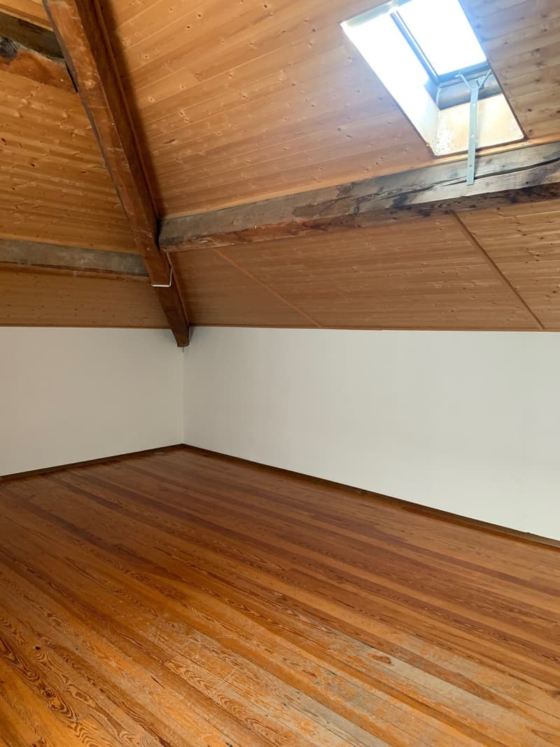 empty attic room with wooden floor and ceiling, skylight window