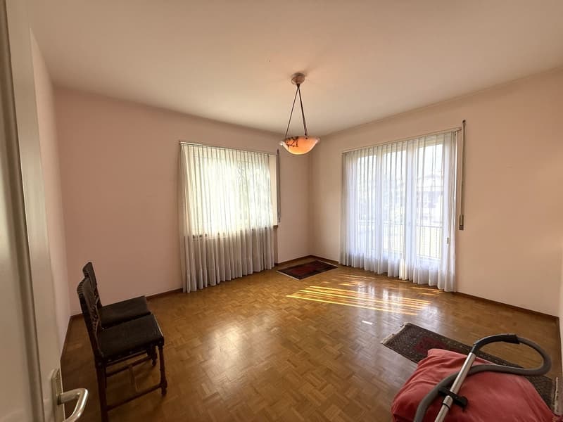 Empty room, hardwood floor, chandelier, curtains, sun light