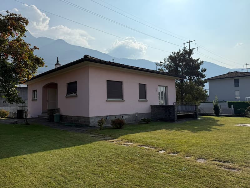 single-family house, pink facade, tiled roof, well-kept garden, mountains in the background